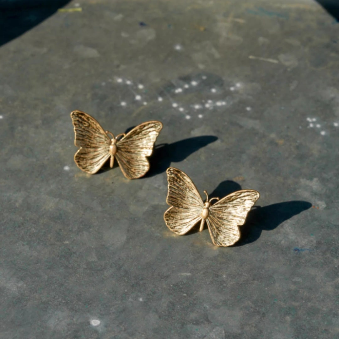 Pair of 18k gold plated butterfly earrings showing intricate wing texture.