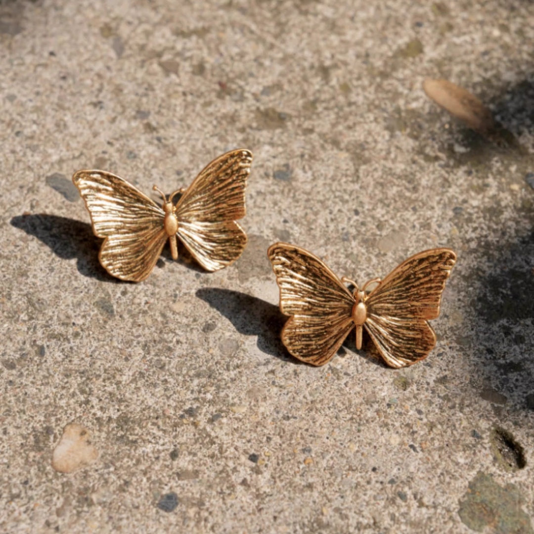 Pair of 18k gold plated butterfly earrings showing intricate wing texture.