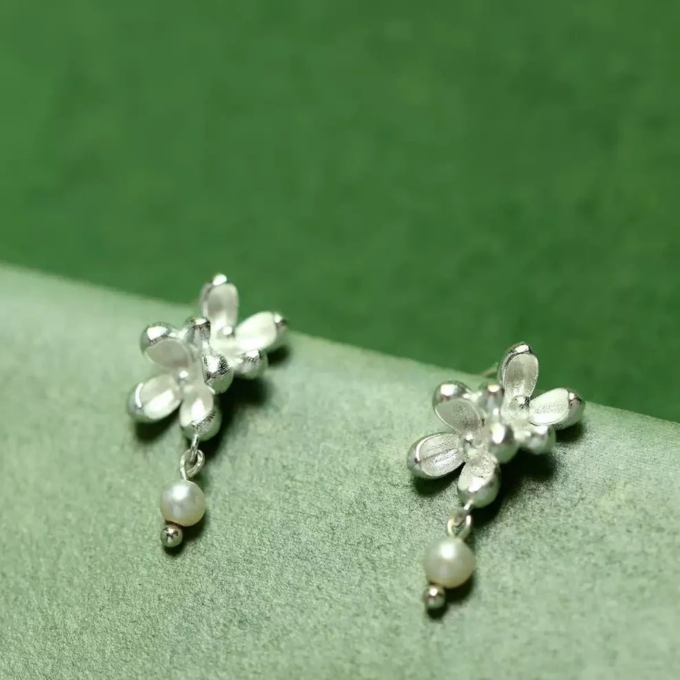 Close-up shot showing the matte texture of silver flower petals and the luster of a natural freshwater pearl -4