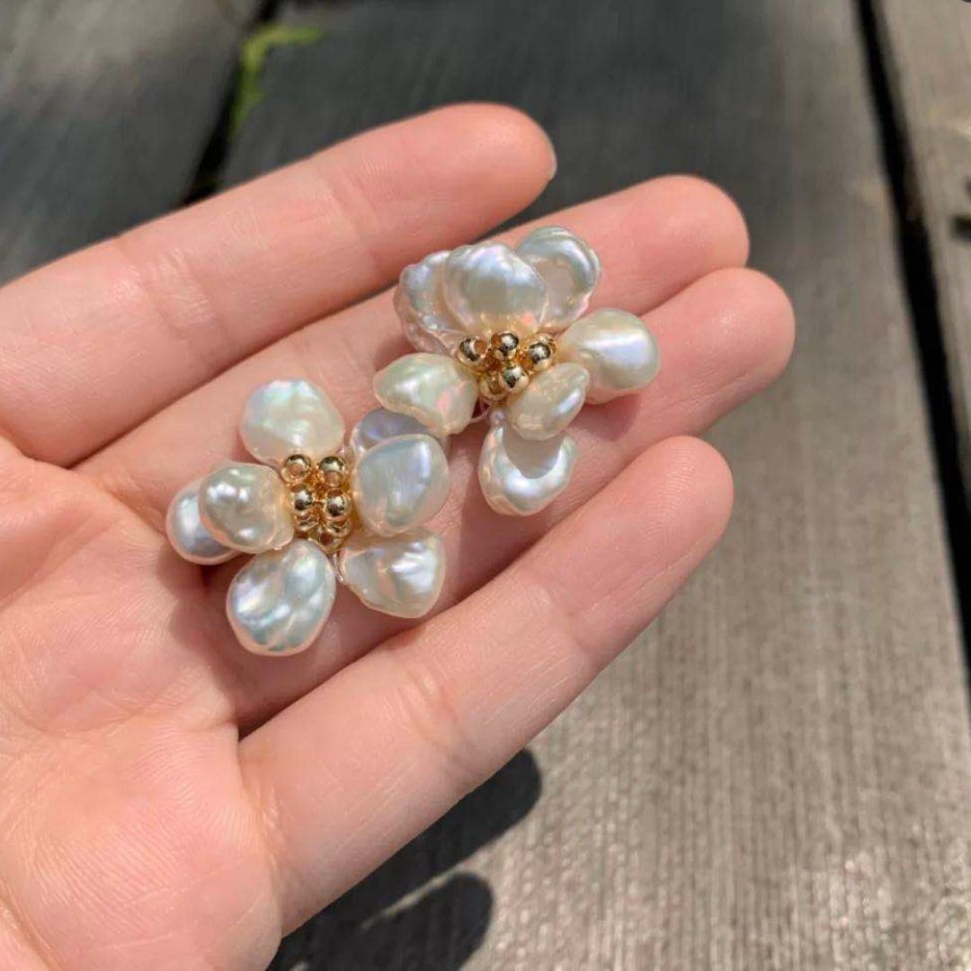 A pair of handcrafted pearl flower stud earrings featuring baroque freshwater pearls and gold bead accents in the center. These dainty pearl flower earrings are perfect bridal flower earrings and floral wedding earrings, making them an elegant choice for statement wedding bridal jewelry.