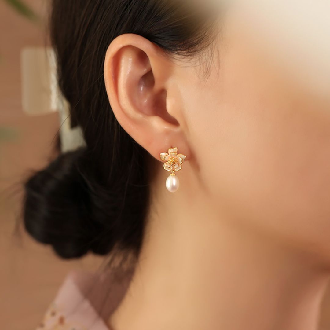 Close-up of gold sakura charm earrings featuring pink petals and pearls, designed as sakura pearl earrings and Flower Stud Earrings—perfect for Cottage core earrings and Cherry Blossom Earrings styles.
