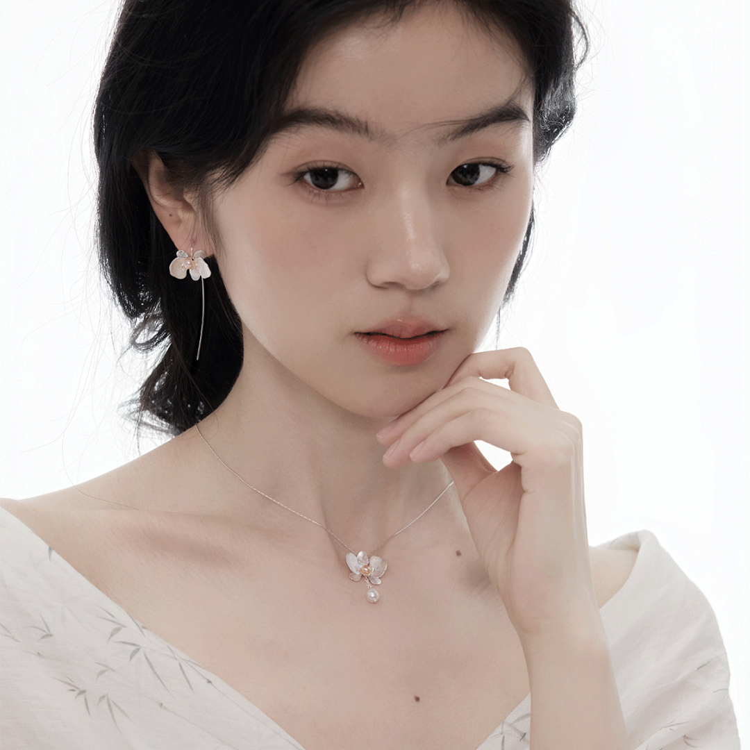 Botanical Realism Exquisite orchid jewelry detail featuring the natural luster of a dangling freshwater pearl.